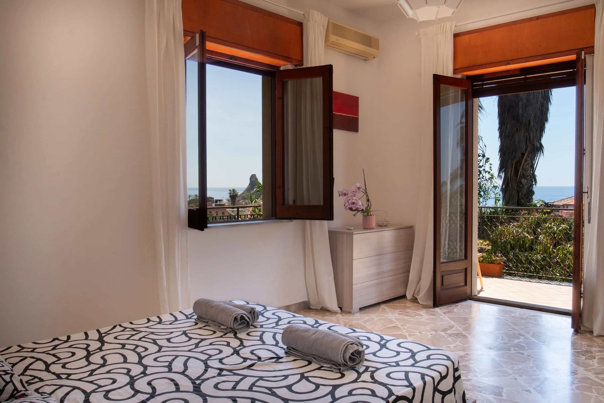 Double bedroom with a French window onto the balcony and the faraglioni in the distance.