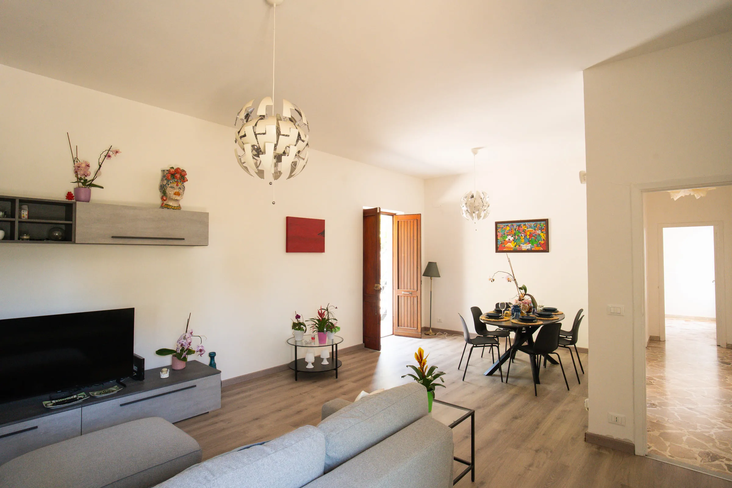 The living room looking through to the dining area, with pale wood flooring.