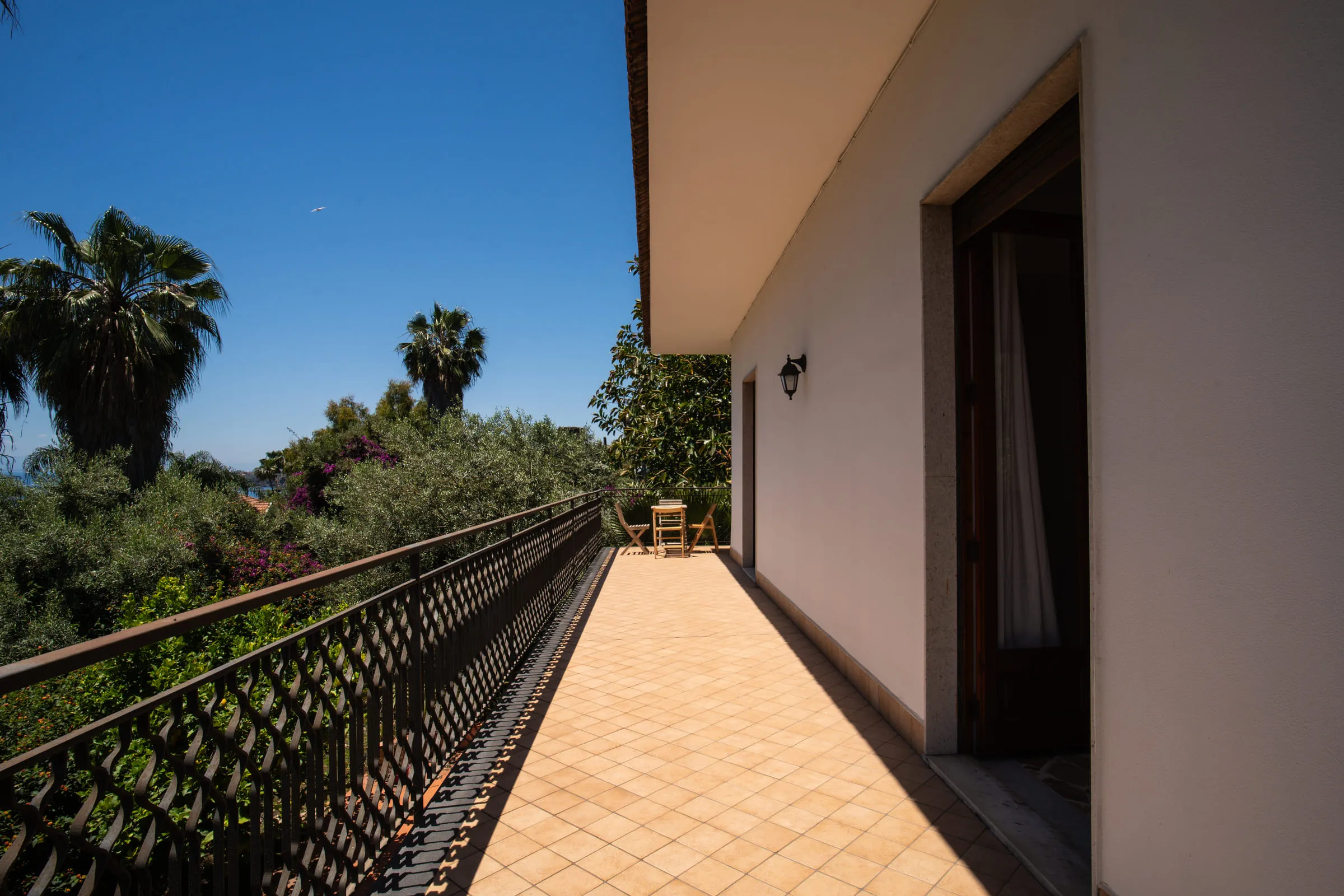The outdoor walkway along the side of the house, leading to the terrace.
