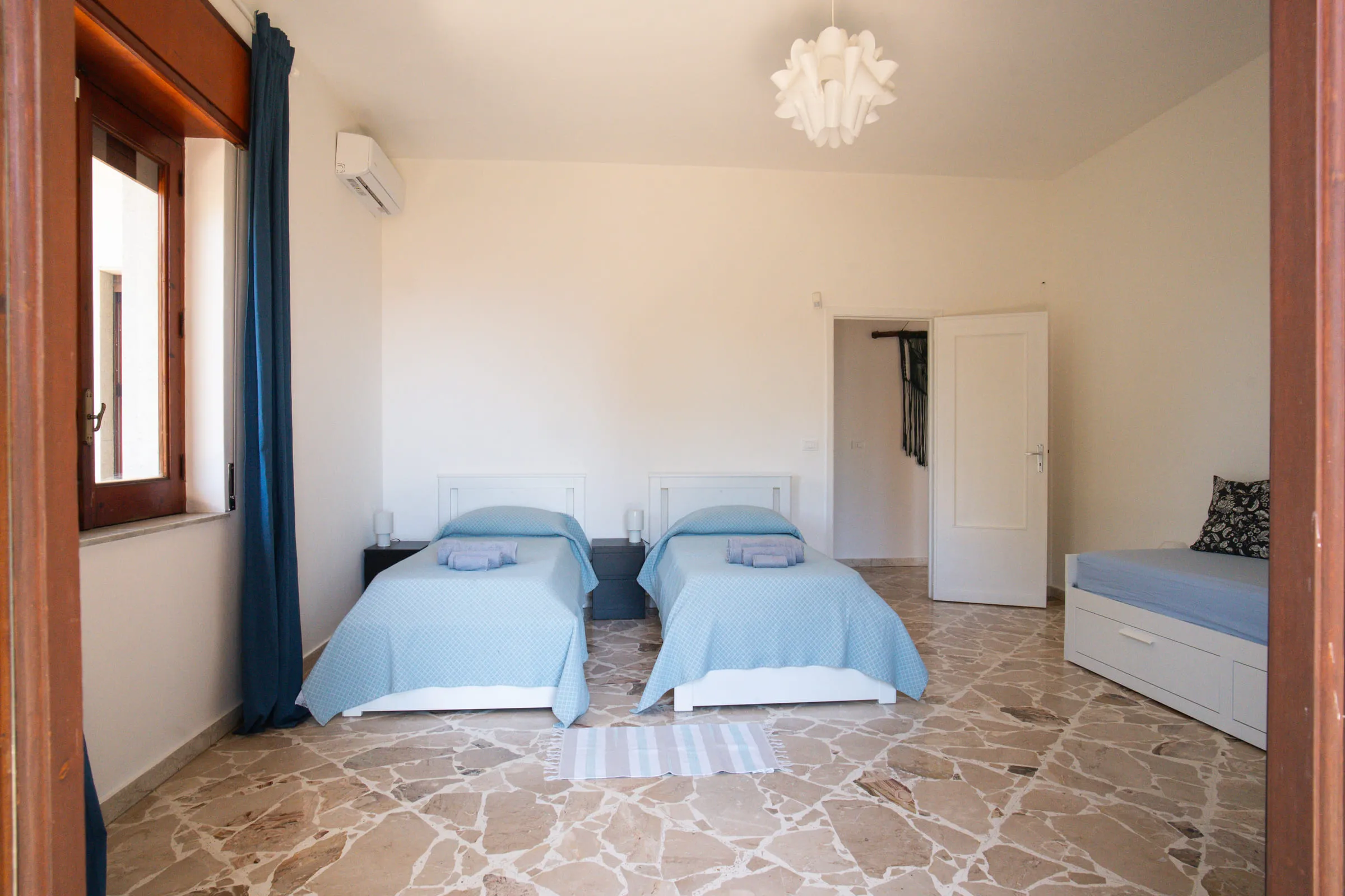 Bedroom with two single beds and a window onto the greenery.
