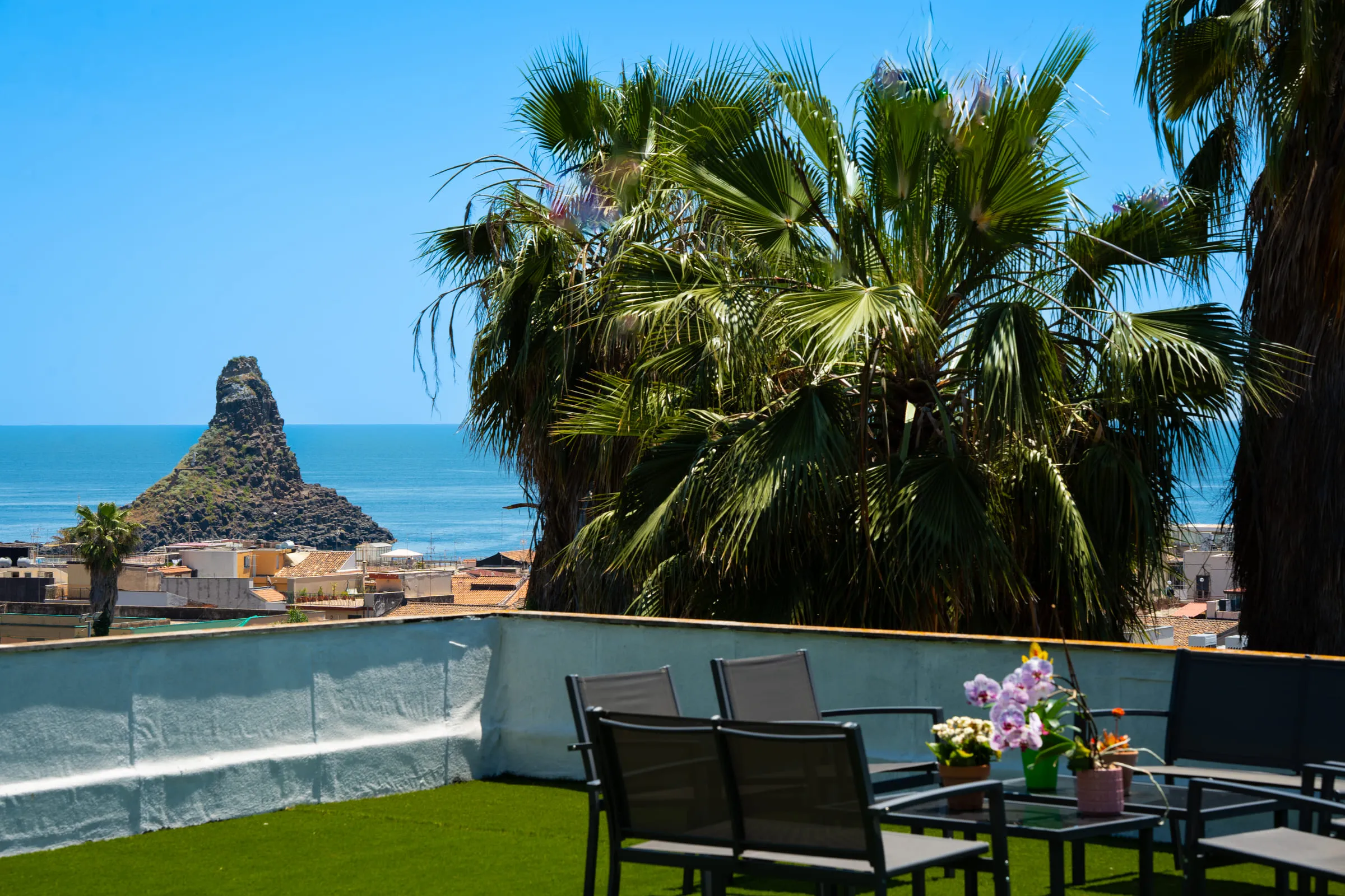 The panoramic terrace with the faraglione and the village rooftops behind.