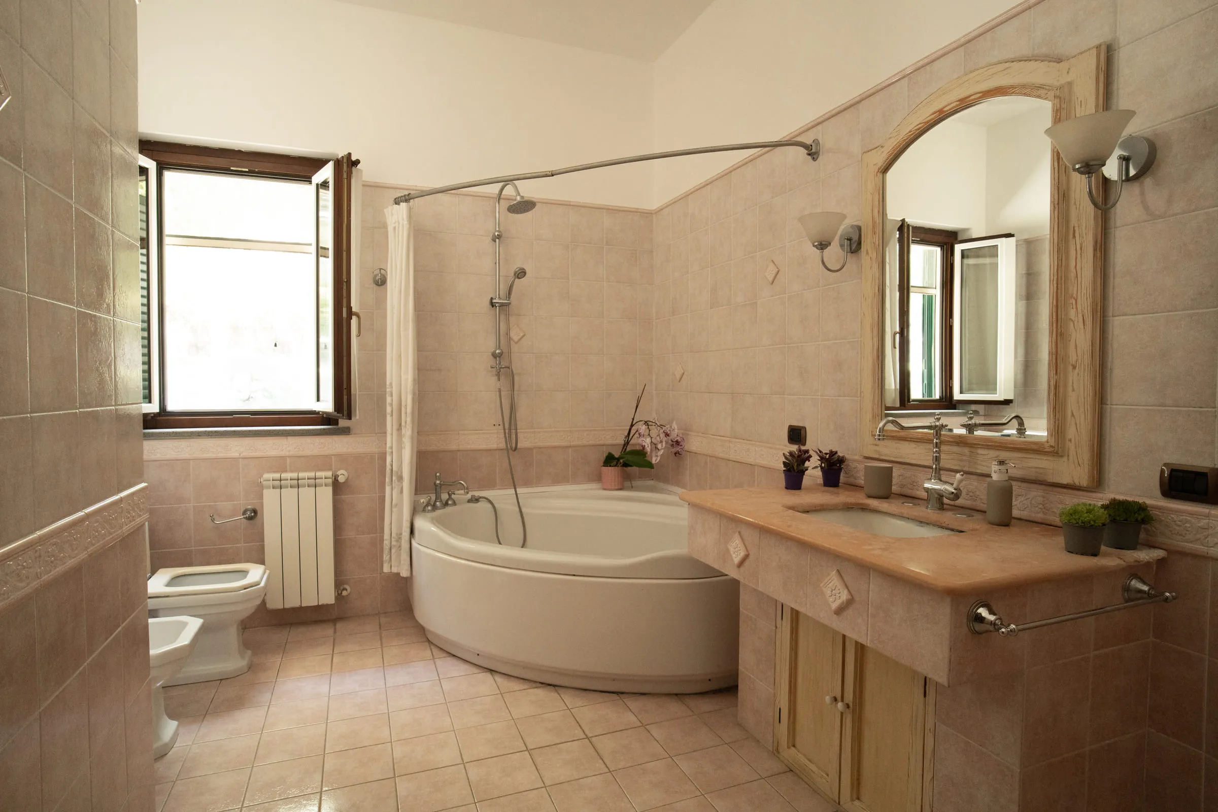 Bathroom with a corner bath, shower and built-in basin.