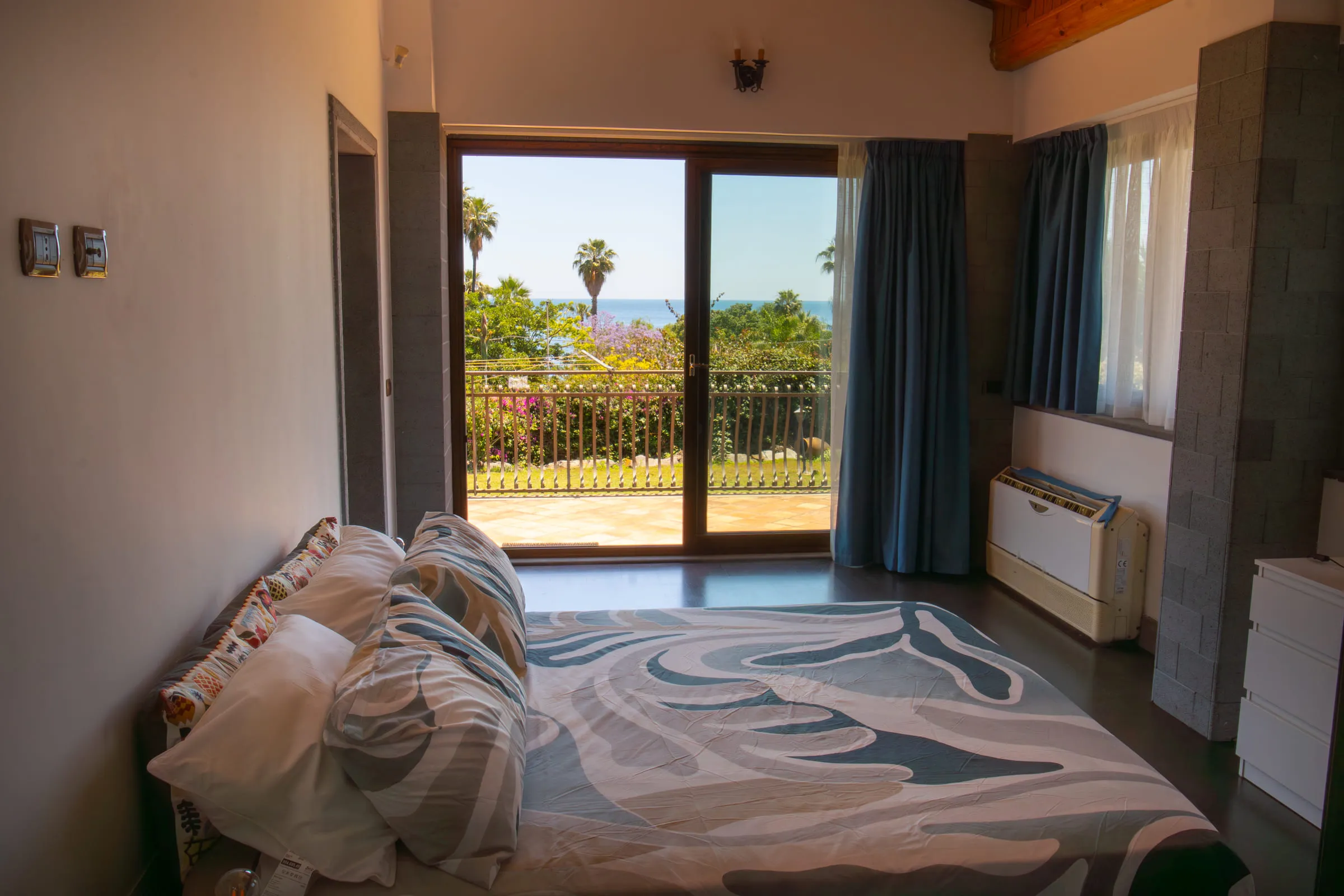 Double bedroom with a sliding door onto the garden and the sea in the distance.