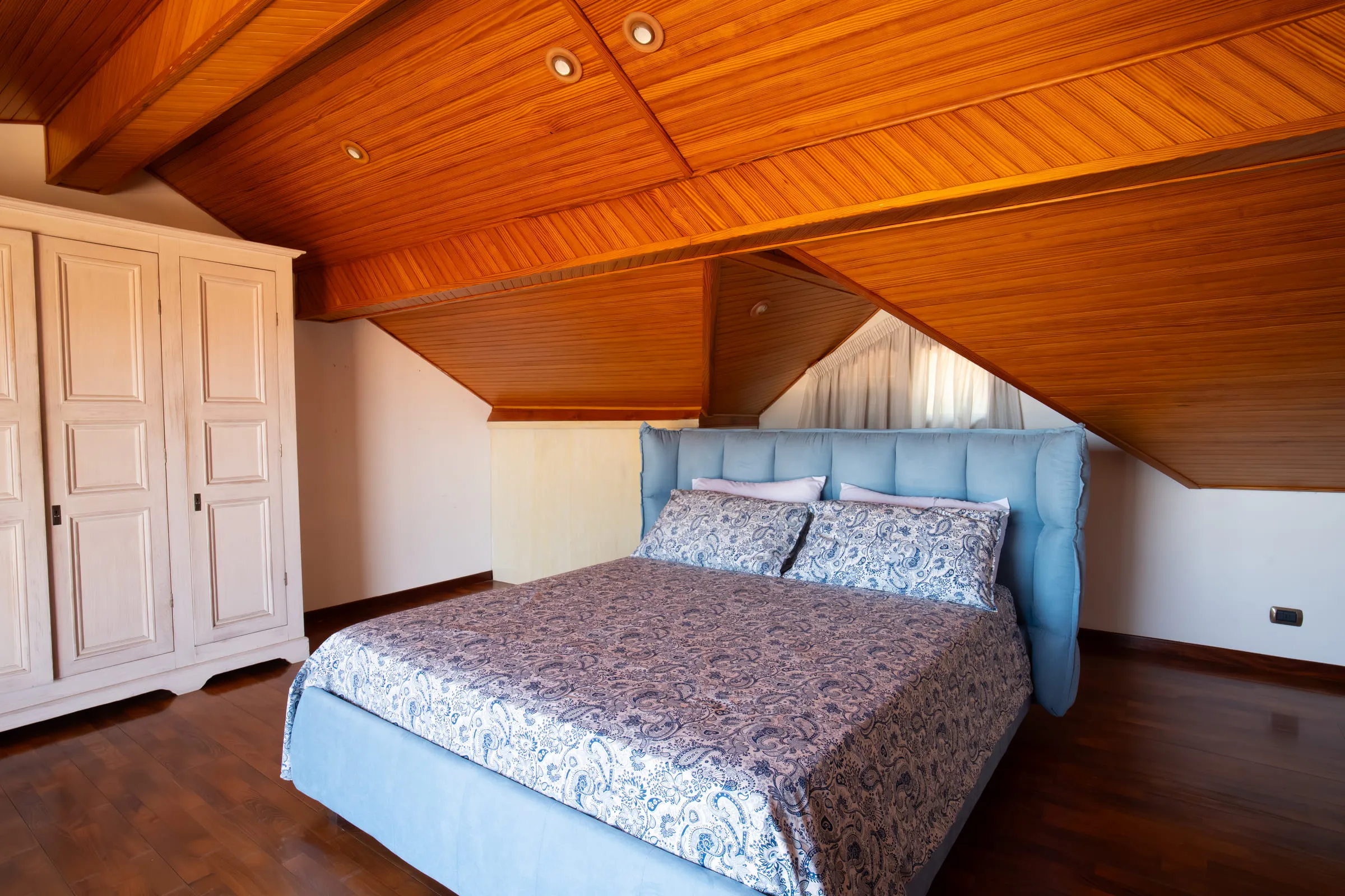 Attic double bedroom with an exposed timber ceiling.